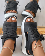 Black open-toe lace-up sandals shown worn.
