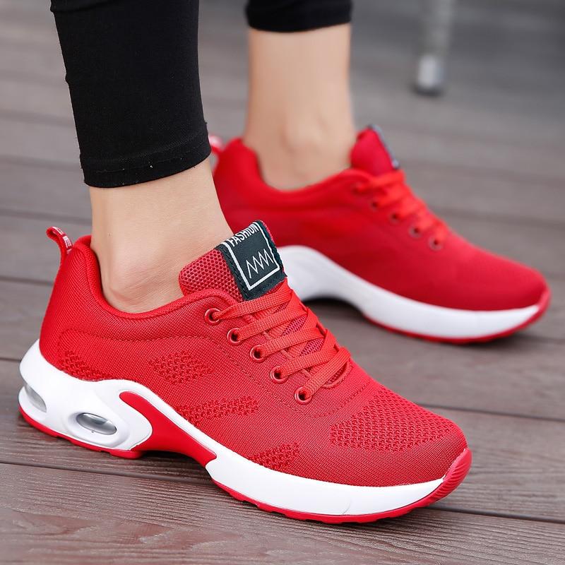 Red lace-up trainers with white sculpted soles and oval heel details.