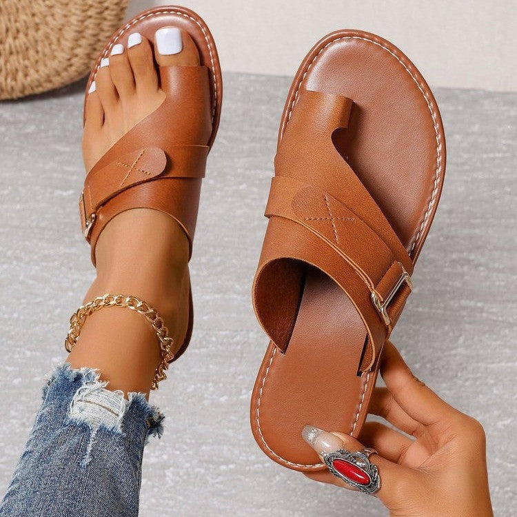Brown slide sandal held beside the matching sandal with a stitched-edge footbed.