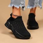 Black slip-on trainers with textured uppers and black soles.