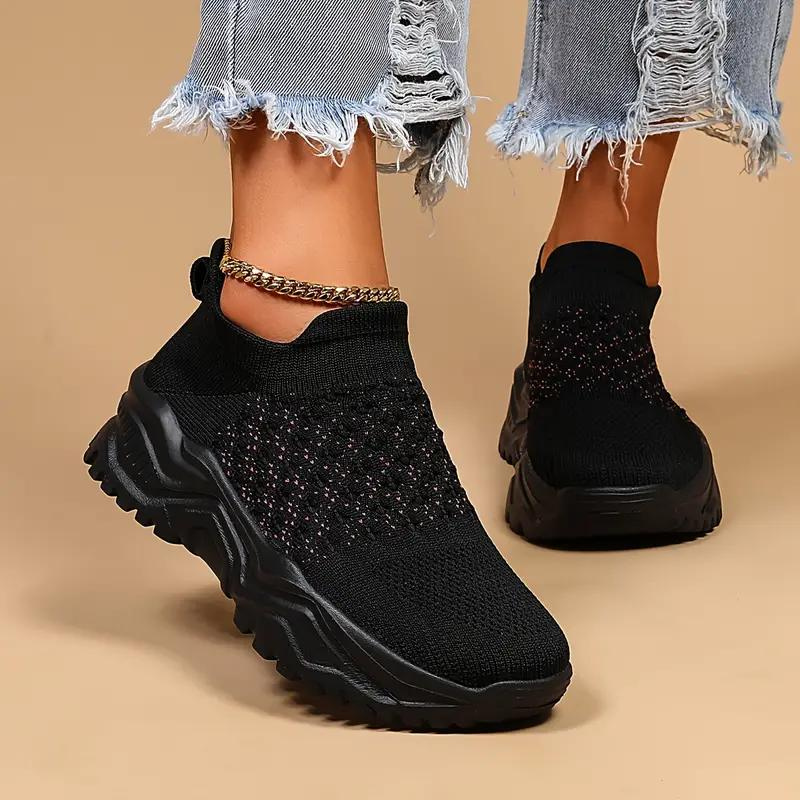 Black slip-on trainers with textured uppers and black soles.