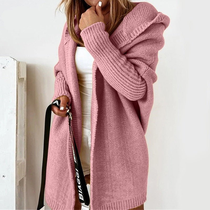 Pink hooded cardigan worn open over a white top.