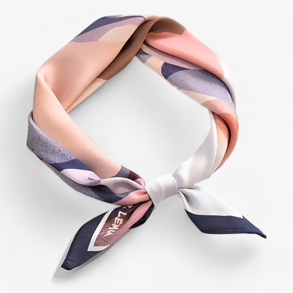 Pink patterned scarf with dark edging and visible lettering near one end.