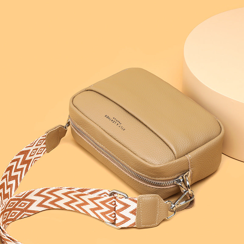 Khaki bag shown from above with its top zip and strap clips.
