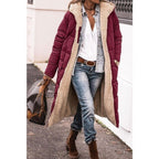 Burgundy long jacket with a hood and quilted sleeves.