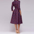 Rear view of the navy dress with small red motifs.