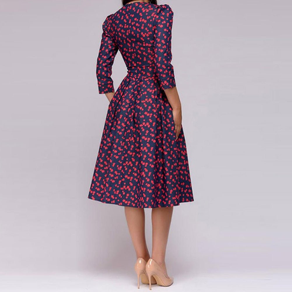 Rear view of the navy dress with small red motifs.