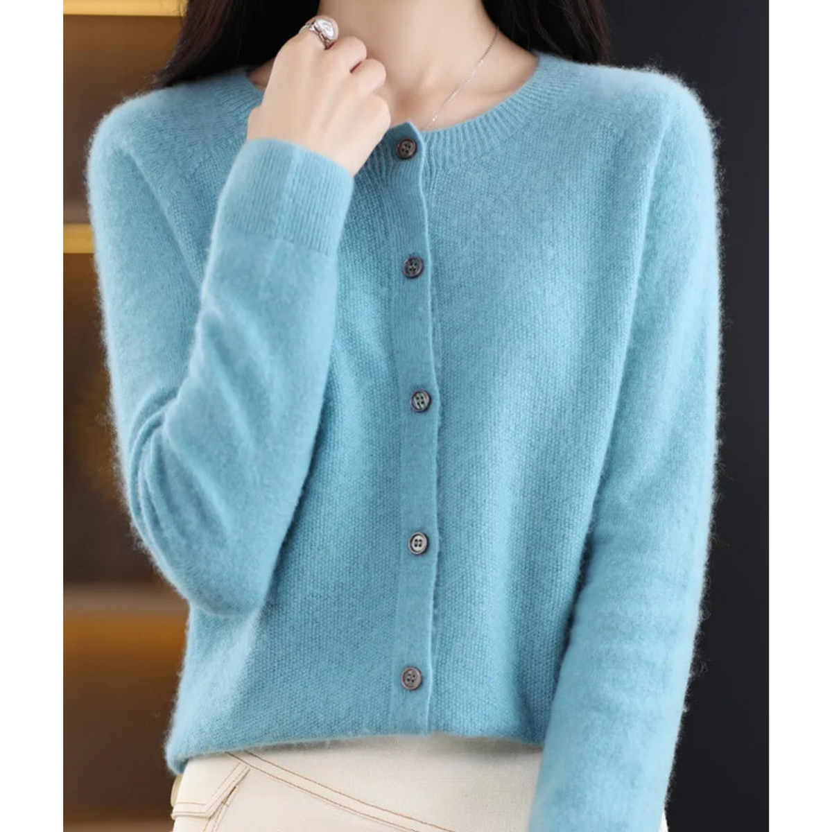 Light blue cardigan with a round neckline and ribbed cuffs.