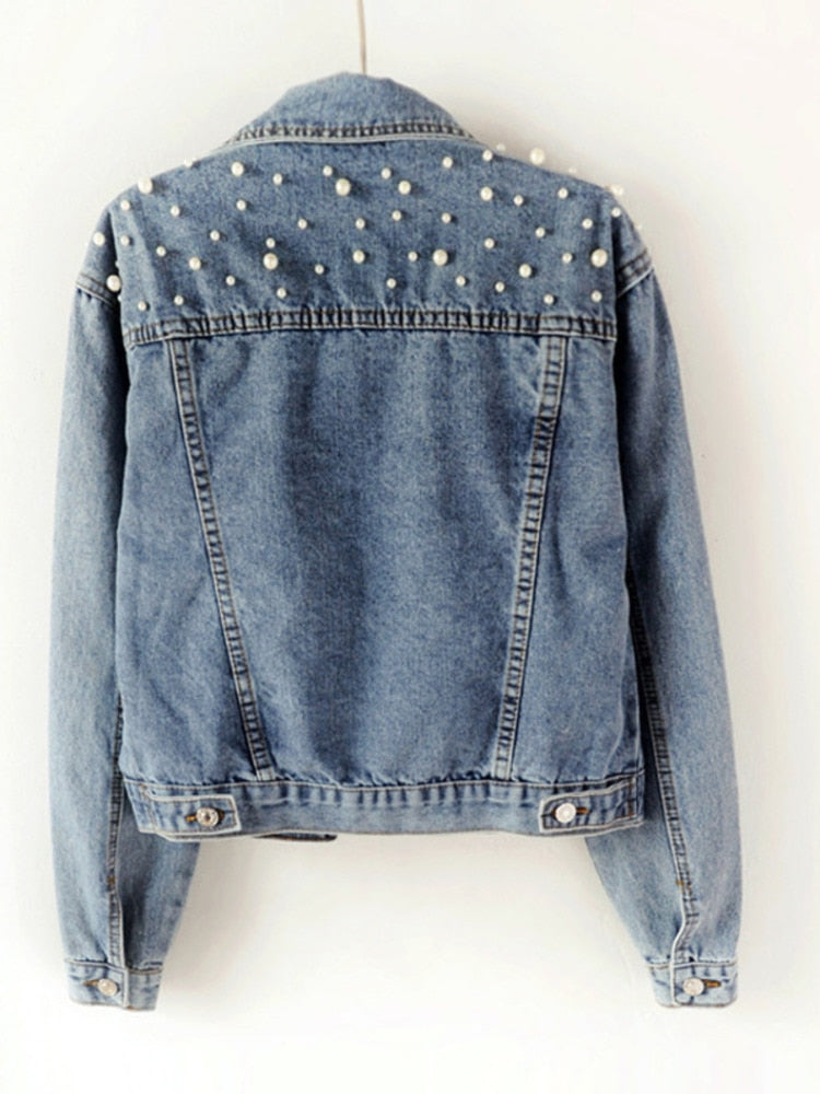 Rear view of a denim jacket with pearl-style beads across the upper back.