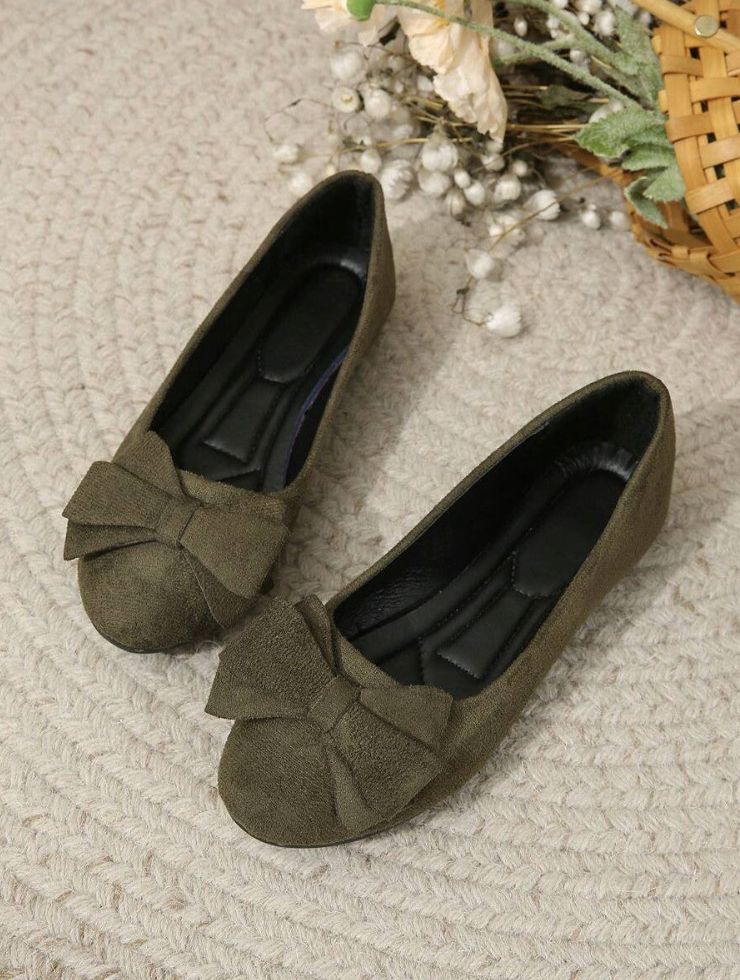 Pair of dark green flats with rounded toes and bow details.