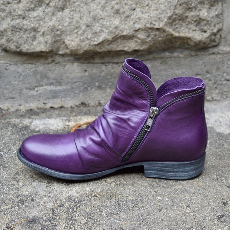 Purple ankle boot with a ruched upper and angled zip.