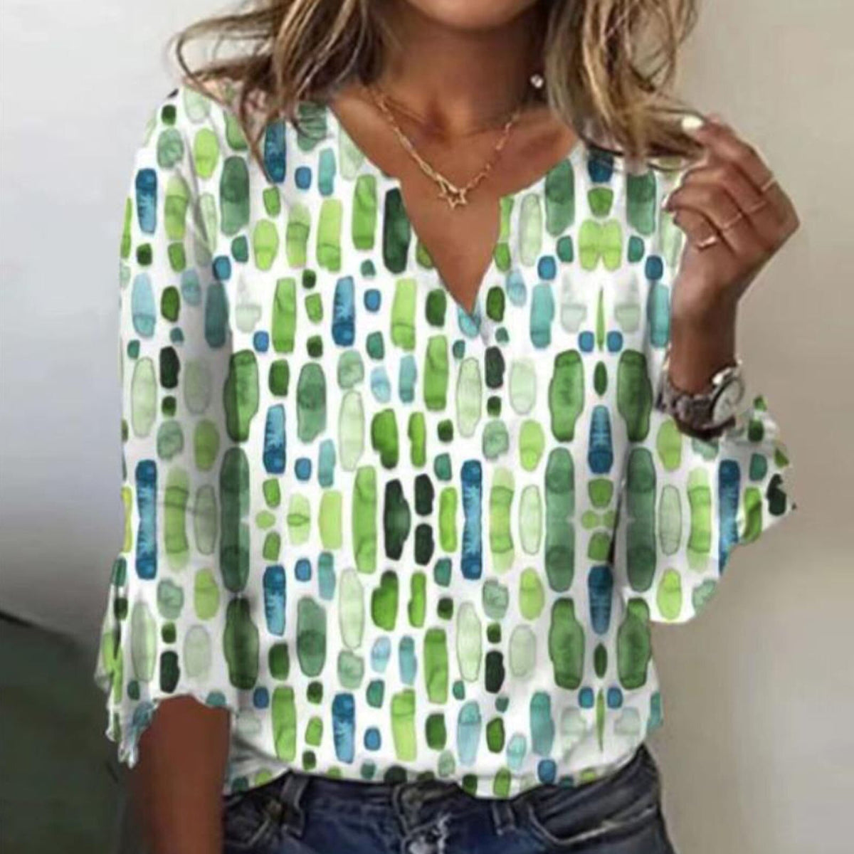 Green and blue abstract-print blouse with a split neckline and flared sleeves.