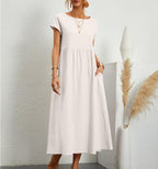White Ginovu dress with a round neckline and gathered waist.