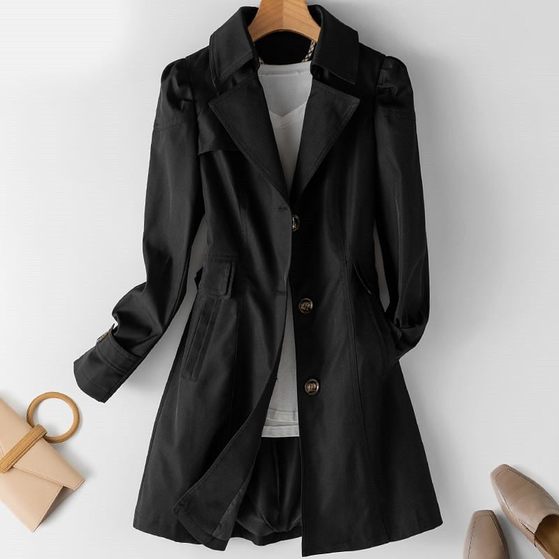 Black long jacket with shaped shoulders and notched lapels, displayed over a white top.