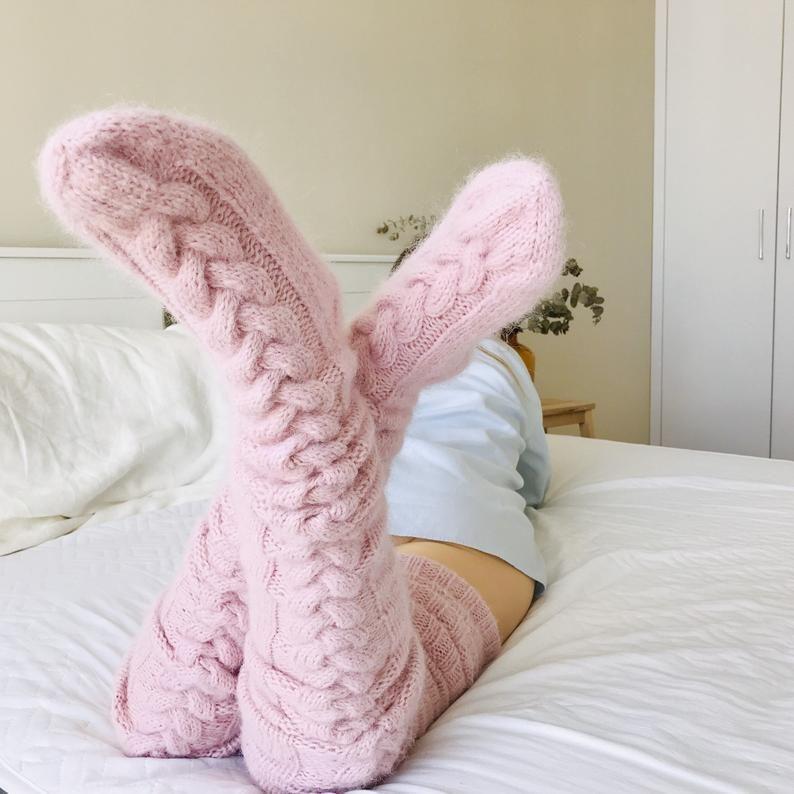 Pink long socks with prominent cable-knit texture.