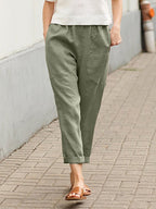 Green Dayanara trousers worn with a white top.