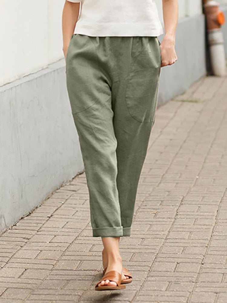 Green Dayanara trousers worn with a white top.