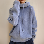 Grey jumper with a ribbed hem and long drawstrings.