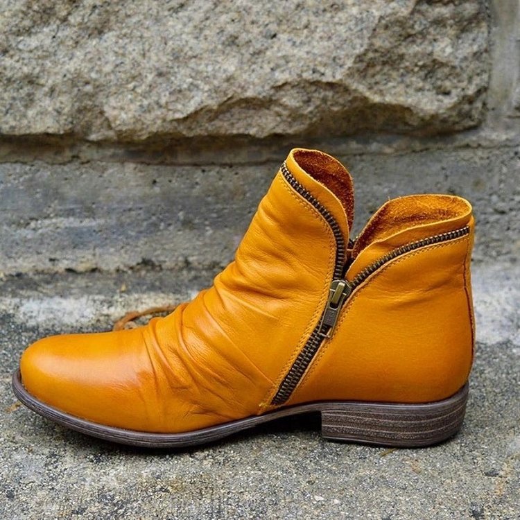 Yellow ankle boot shown from the side with its zip open.