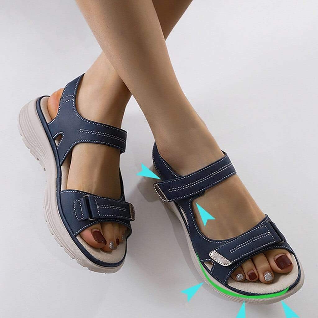 Dark blue sandals with turquoise source arrows pointing around the straps and toe.