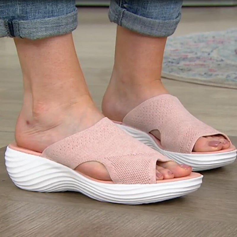 Pink open-toe sandals with thick white soles.