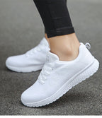 White trainers viewed from the side with rear pull loops.