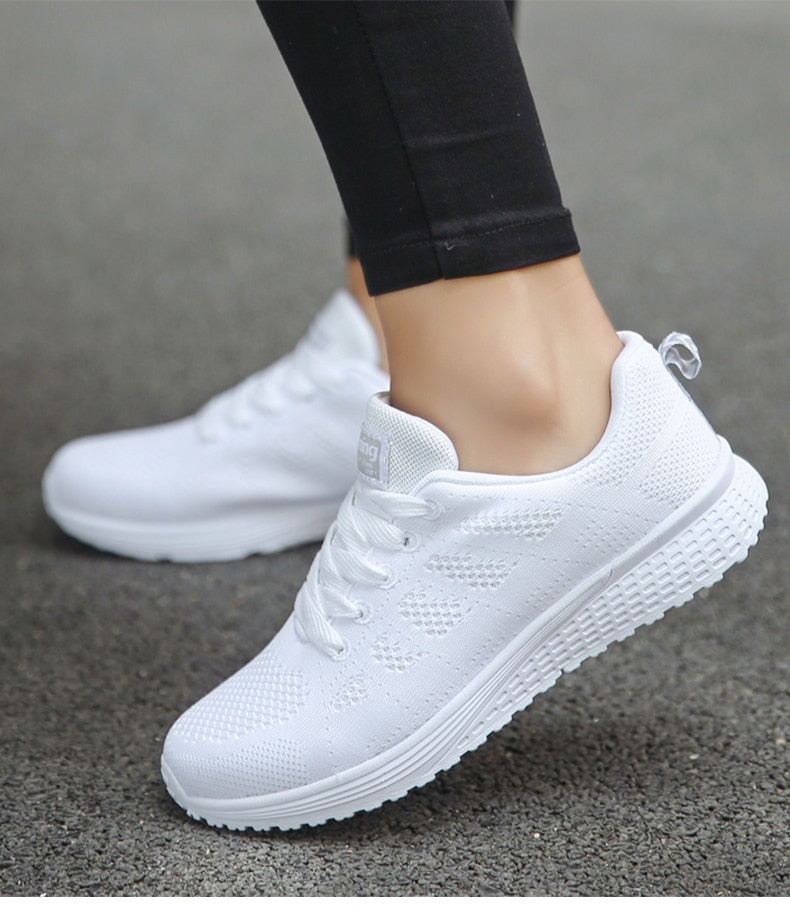 White trainers viewed from the side with rear pull loops.