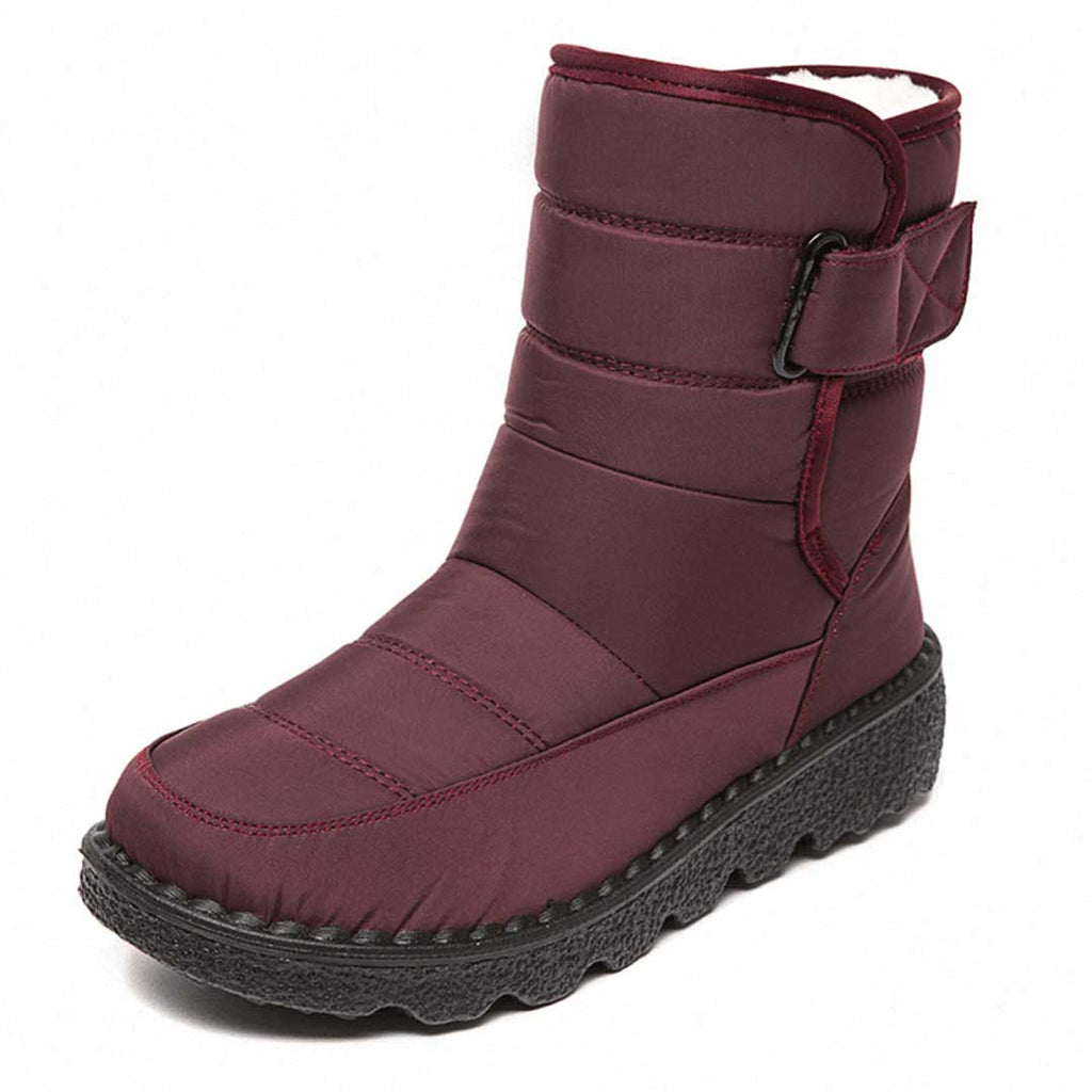 Red winter boot with horizontal stitching, an upper strap and a textured dark sole.