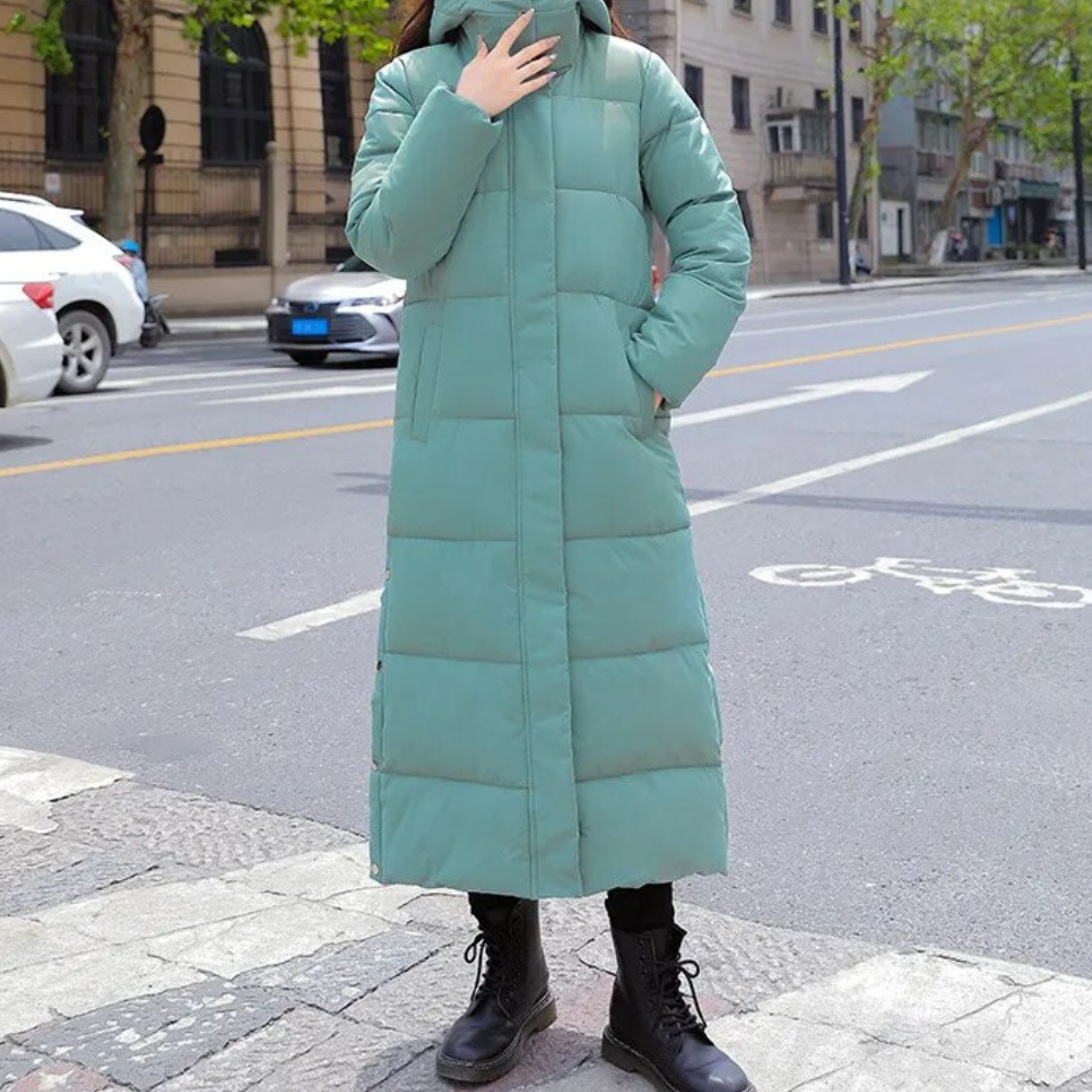 Green long quilted hooded coat with side pockets, shown being worn.