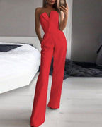 Red strapless jumpsuit with an angular folded neckline and fitted waist.