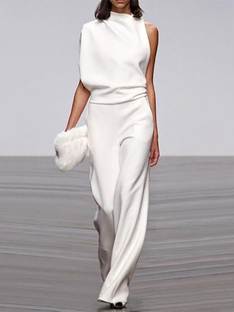 White jumpsuit with a high neckline, waist folds and wide legs.