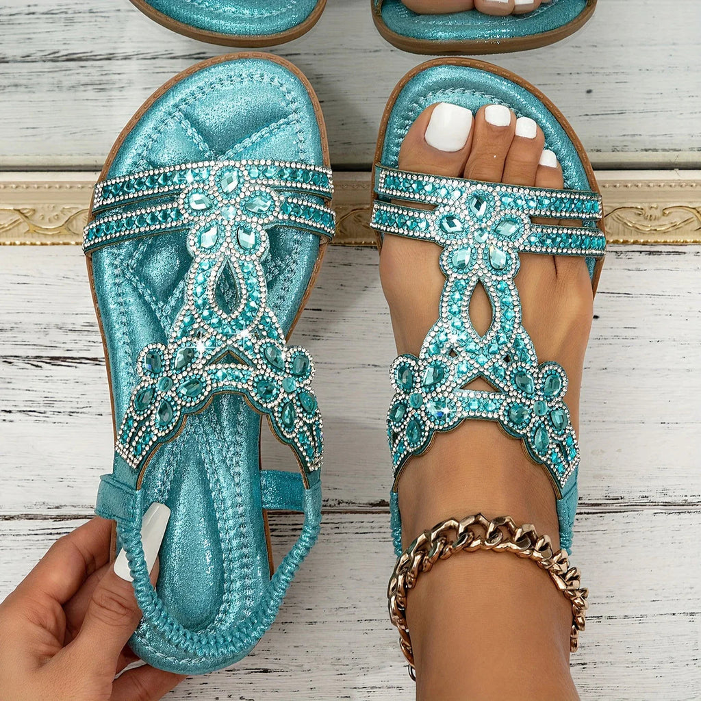 Turquoise sandals with shiny floral edging and a heel strap.