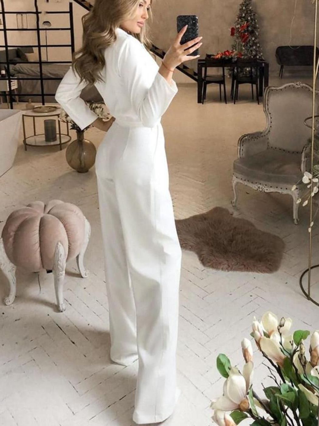 Rear view of a white long-sleeve jumpsuit.