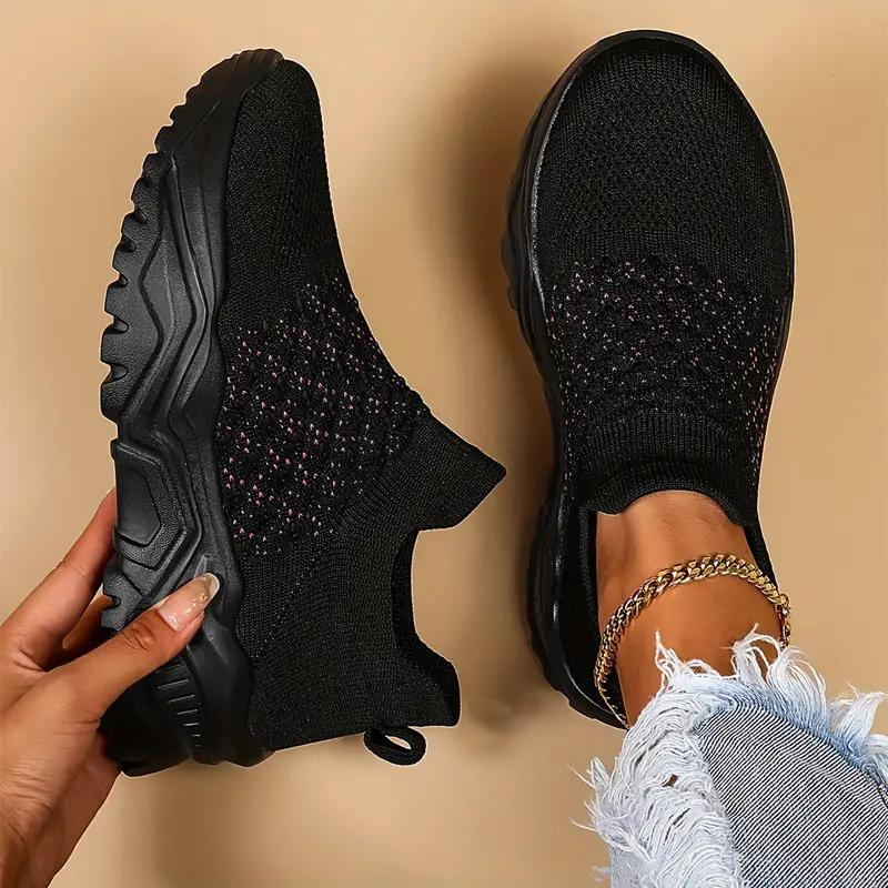 Black trainers shown from above with textured front panels.