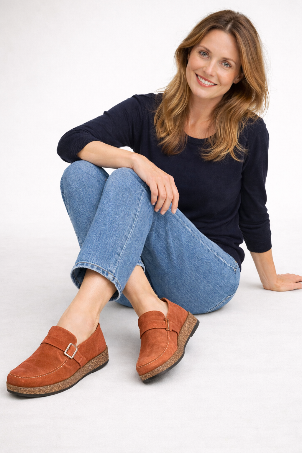 Rust-coloured buckle clogs worn with jeans.