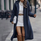 Navy blue long faux-fur coat worn open over a white dress.