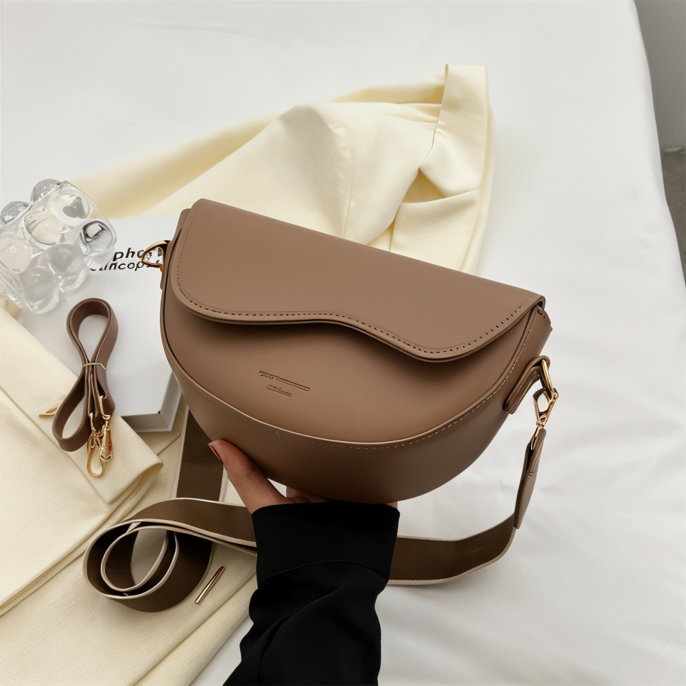 Angled front view of a taupe shoulder bag showing its rounded body.