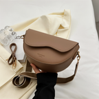 Angled front view of a taupe shoulder bag showing its rounded body.