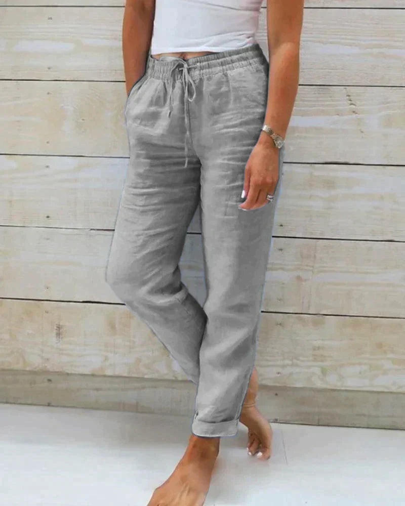Grey drawstring trousers with rolled hems.