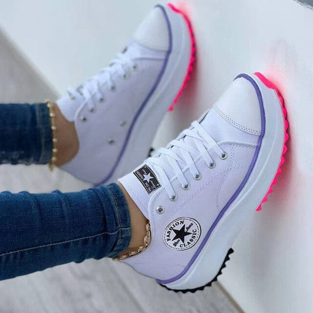 White lace-up trainers with purple sole edging and bright pink tread.