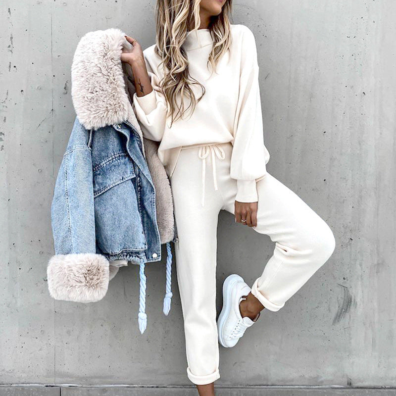 White lounge set worn while holding a separate denim jacket.