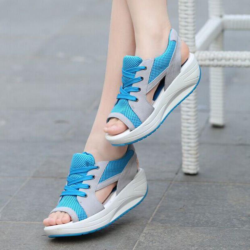 Blue sandals with broad grey lace panels shown worn.