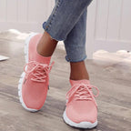 Pink lace-up trainers with textured uppers and segmented white soles.