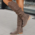Grey suede boots with side zips and low tan heels.