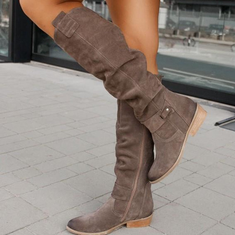 Grey suede boots with side zips and low tan heels.