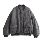 Grey quilted bomber jacket with ribbed edges and two flap pockets.