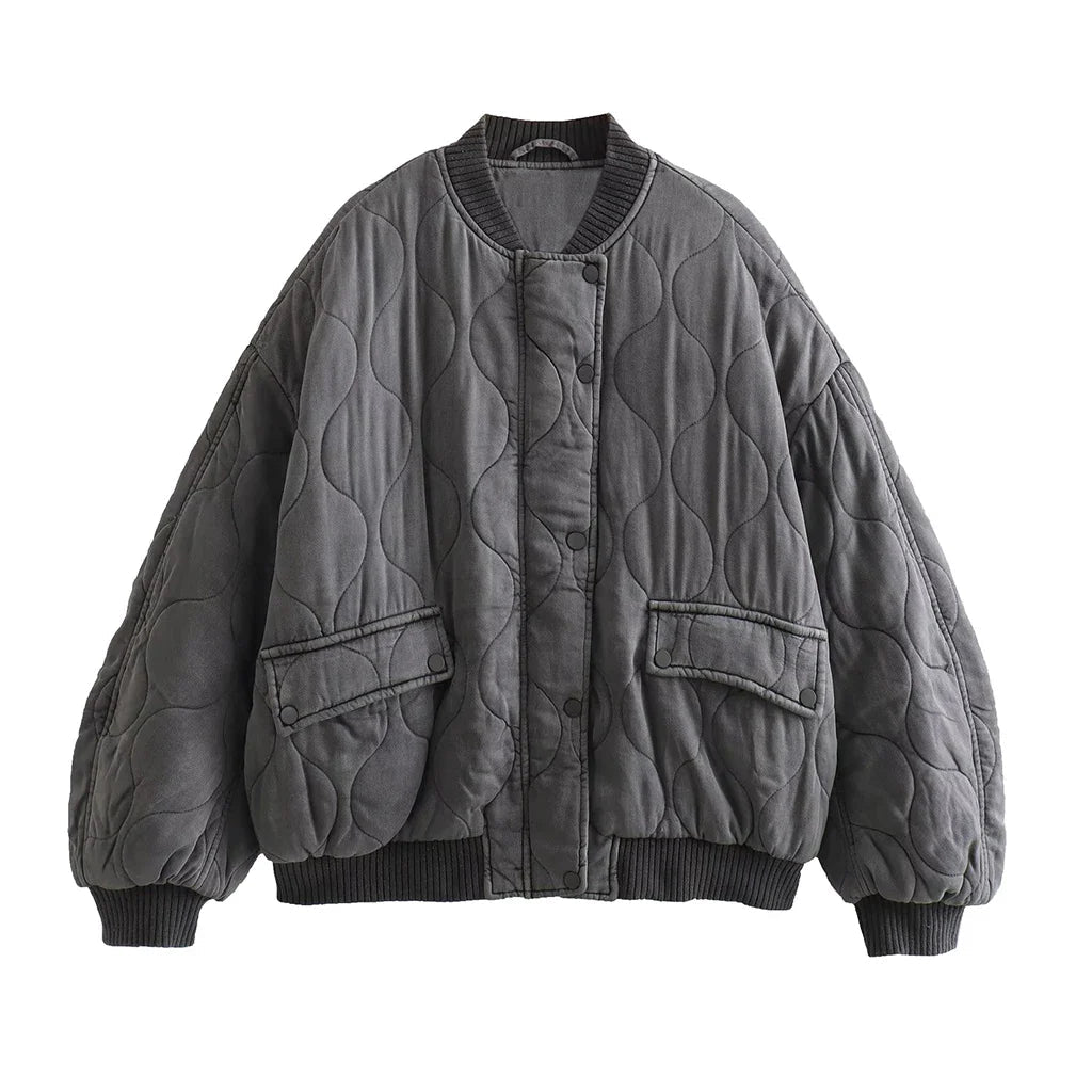 Grey quilted bomber jacket with ribbed edges and two flap pockets.