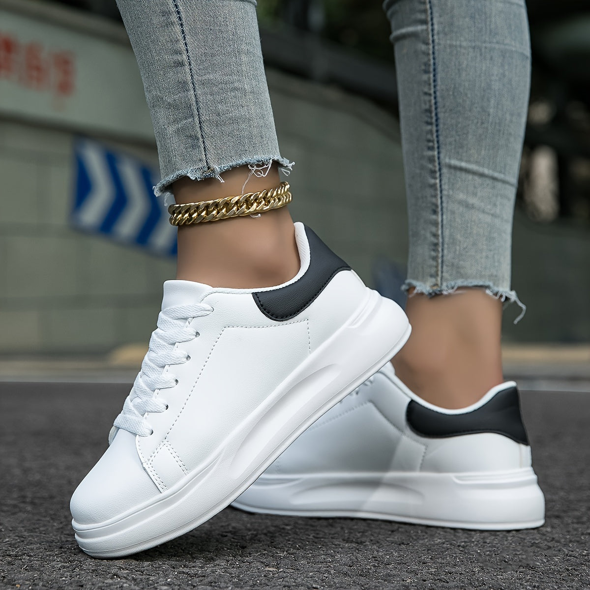 White and black lace-up trainers with thick white soles.