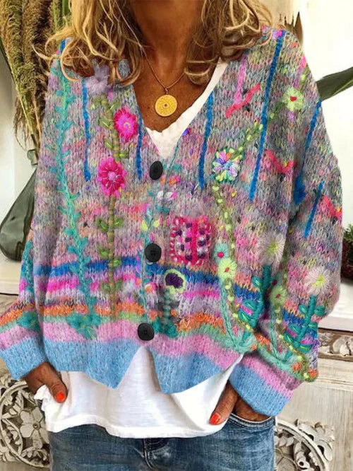 Grey-toned cardigan with colourful floral and stripe motifs and dark buttons.