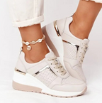 Beige trainers worn with cropped light trousers.